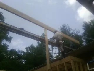 Carpenter setting a ridge beam over a new addition frame — Ice Dam Removal by Roofing Brothers in Nampa