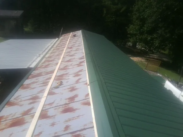 Old rusted panels beside newly installed green metal roofing — Wind Damage Roof Repair by Roofing Brothers in Nampa