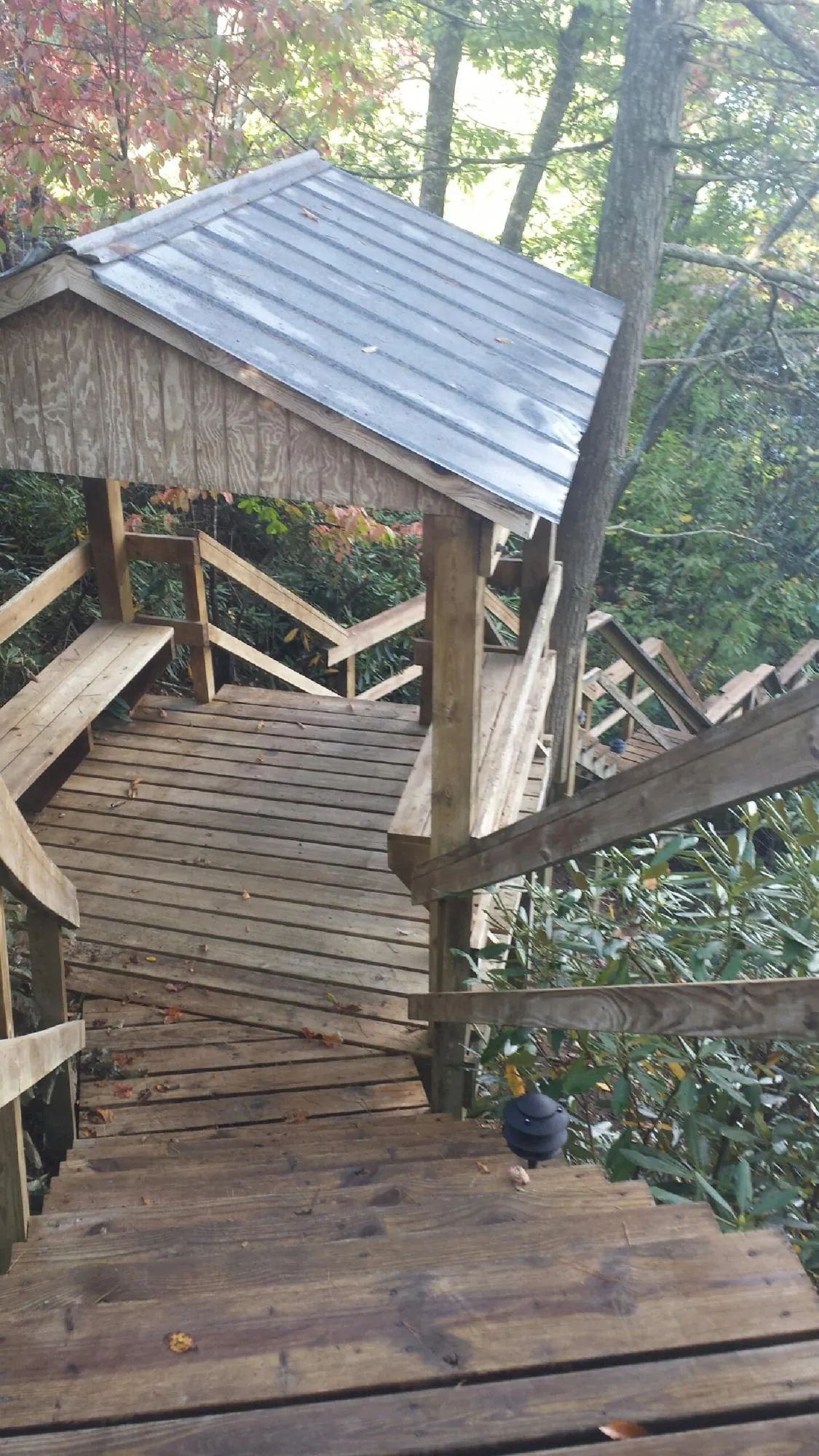 Metal roofed shelter over wooden steps on a wooded walkway — Skylight Repair & Installation work by our crew in Nampa